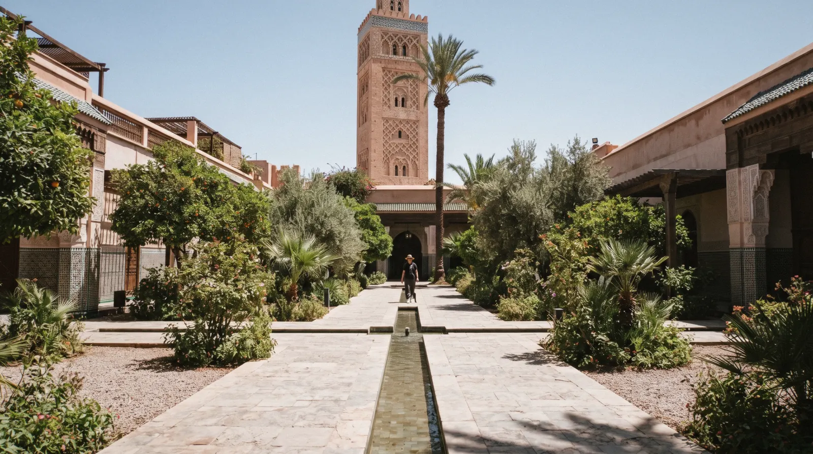 Water channel splitting the clipped beds of the Islamic garden with the tower behind, Le Jardin Secret in the Marrakech medina