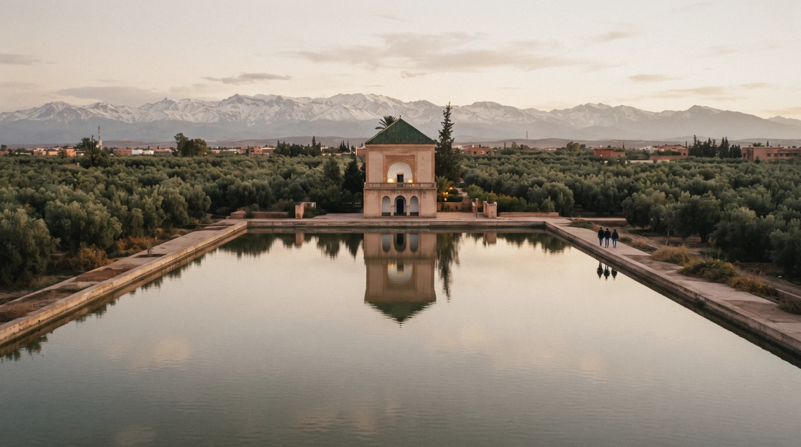 The green-tiled pavilion reflected in the great basin with the Atlas snow line behind, Menara Gardens Marrakech