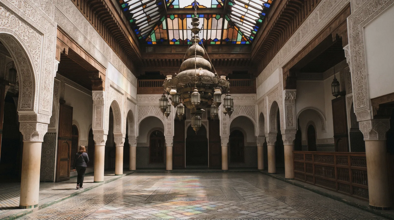 The glazed lantern and zellige courtyard of Dar Menebhi, home of the Musee de Marrakech, seen from the arcade