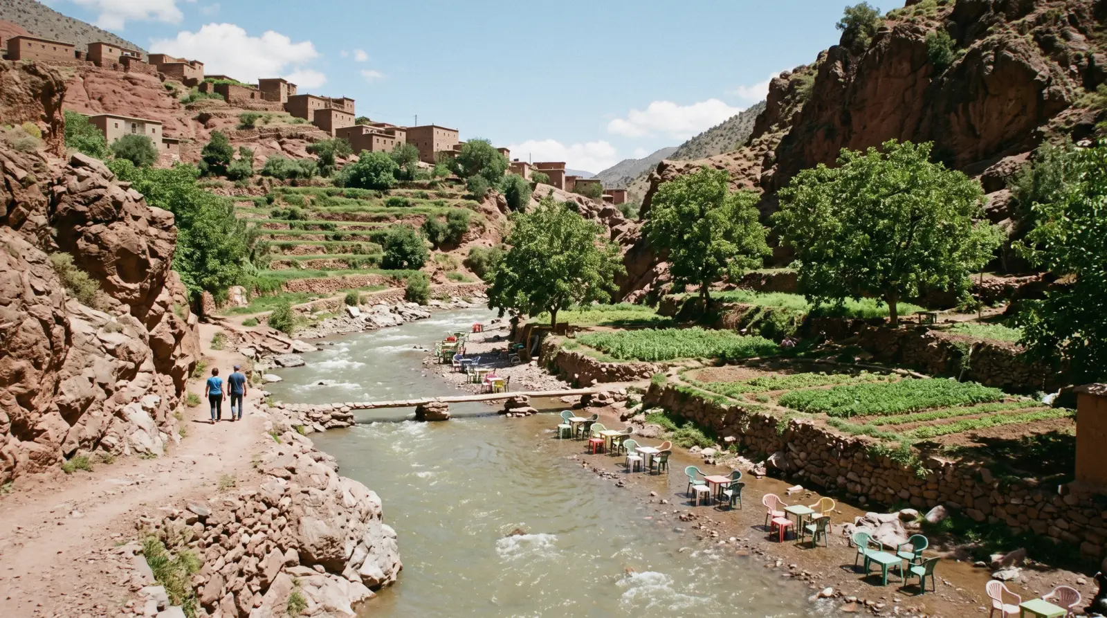 The river running green between red rock walls with terraced walnut plots above, Ourika valley near Marrakech