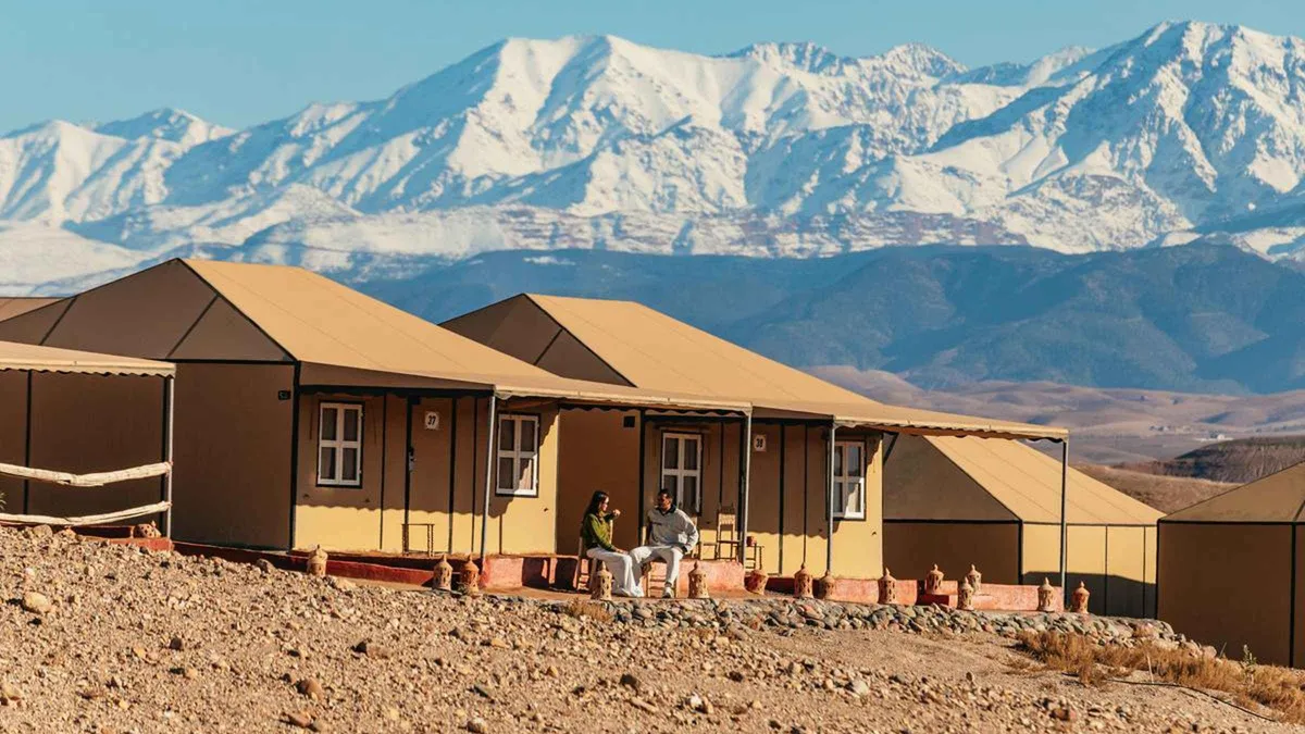 Tented camp with a pool on the ridge of the Agafay desert at dusk on an Agafay desert overnight retreat from Marrakech